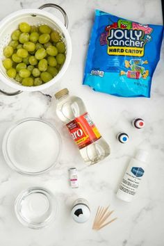 the ingredients to make an ice cream dessert are displayed on a marble countertop, including grapes and yogurt