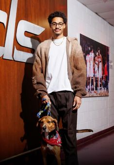 a man standing next to a dog wearing a bandana