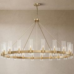 a large chandelier hanging from the ceiling with clear glass tubes and gold fixtures