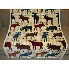 a blanket with moose silhouettes on it is sitting on the floor in front of a couch