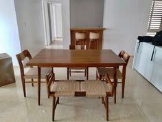 a dining table and chairs in a room with tile flooring, white walls and cabinets