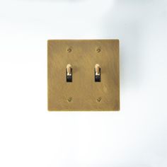 two light switch plates on a white wall