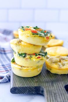 several small muffins are stacked on top of each other with spinach and cheese