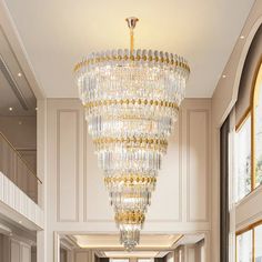 a large chandelier hanging from the ceiling in a room with white walls and windows