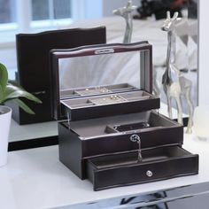 two jewelry boxes sitting on top of a table