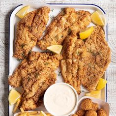 fried fish and fries on a plate with dipping sauce