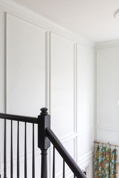 an empty room with white walls and black railings