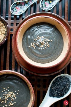 three bowls filled with different types of food on top of a table next to spoons