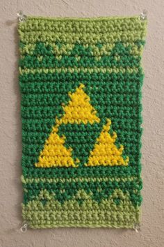 a green and yellow crocheted wall hanging