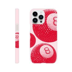 an iphone case with red and white balls on it, sitting next to a pen