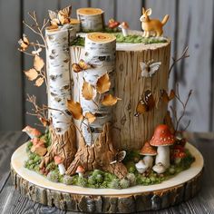 a cake made to look like a tree stump with mushrooms and leaves on it is sitting on a table