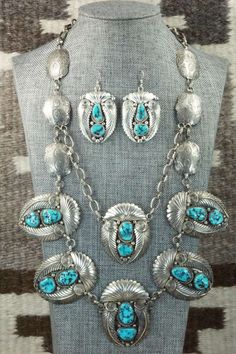 This vintage turquoise and sterling silver necklace and earrings set was made by Navajo silversmith Nora Tsosie. The back of the necklace is signed NT and stamped sterling. Please note this is a pre-owned piece, with patina, in vintage condition.Necklace: 28"Length: 2 1/8"Width: 1 3/4"Earrings:Length: 2 1/4"Width: 1 1/4"Free shipping on all orders! We ship with USPS and always include tracking. All orders ship within a day of payment.Returns are accepted up to 30 days after you receive your orde Engraved Turquoise Southwestern Jewelry, Southwestern Hallmarked Silver Jewelry, Sterling Silver Turquoise Concho Jewelry, Elegant Turquoise Concho Jewelry, Traditional Turquoise Jewelry Stamped 925, Turquoise Concho Jewelry For Gifts, Vintage Turquoise Jewelry With Oxidized Finish, Artisan Jewelry With Matching Earrings For Collectors, Southwestern Jewelry With Oxidized Finish