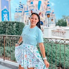 a woman in a blue shirt and skirt posing for the camera with her hand on her hip