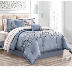 a bed with blue comforters and pillows in a room