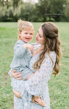 a mother holding her baby girl in the park