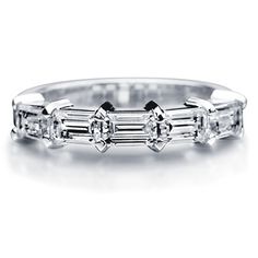 a white gold ring with three baguetts on the side and two diamonds in the middle