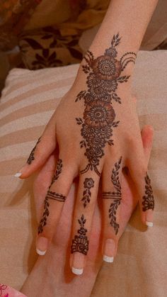 a woman's hand with henna tattoos on it