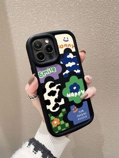 a woman holding up her phone case with cartoon stickers on the front and sides