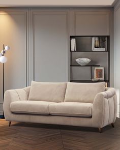 a living room scene with focus on the couch and bookcase in the back ground