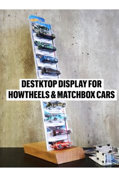 a stack of cars sitting on top of a wooden stand with the words desktop display for how wheels & matchbox cars