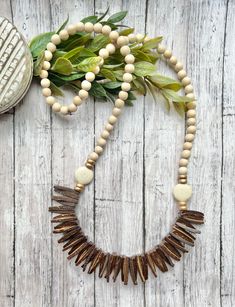 Brown wood statement necklace. Beaded wood stick Necklace. Neutral statement necklace. Beige. Gold. Dark brown coconut bead. An easy necklace to add to any outfit! It measures approximately 30 inches. Lightweight wood beads with an accent round, flat howlite stone bead. Thanks for visiting BeadedBlues! Beige Necklace, Easy Necklace, African Inspired Jewelry, Wood Hoop Earrings, Howlite Stone, Wood Sticks, Beaded Statement Necklace, Necklace Beaded, Small Pendant