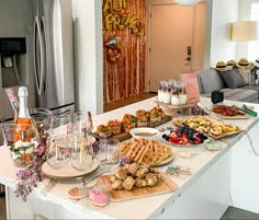 a table filled with food and drinks on top of a kitchen counter next to a refrigerator