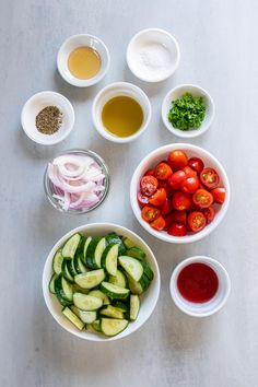 bowls filled with different types of vegetables and sauces on top of a white table