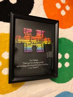 a black frame with colorful crayons on it and a poem written in the center