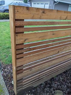 a wooden slatted fence in front of a house