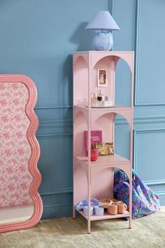 a pink shelf in a room with blue walls