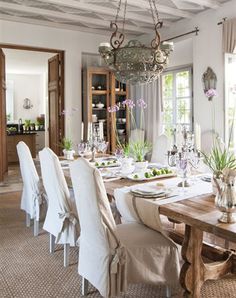 the dining room table is set with white chairs