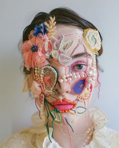 a woman's face covered in beads and flowers