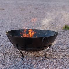 a black fire pit sitting on top of gravel