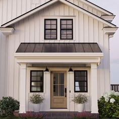 a white house with black trim and two large windows on the front door is shown