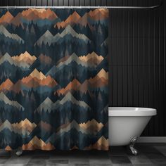 a bath tub sitting next to a shower curtain with mountains on the side of it