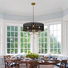 a dinning room table with chairs and a chandelier hanging from the ceiling