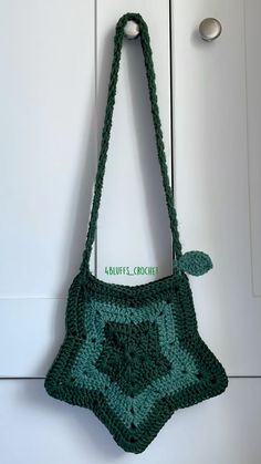 a green crocheted purse hanging from a hook