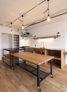 an empty kitchen with wooden floors and white walls