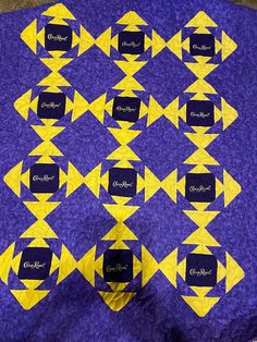 a purple and yellow quilt with black labels on it