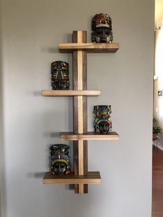 three wooden shelves with masks mounted on them