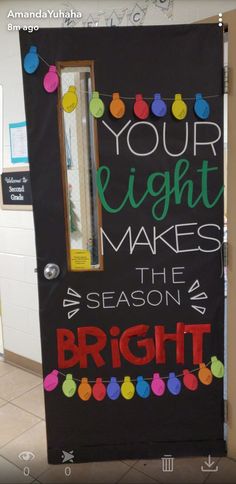 a black door decorated with christmas lights and the words your light makes the season bright