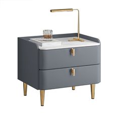 a grey and gold bedside table with a glass on the top, next to a brass faucet