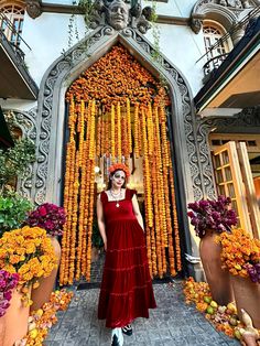 a woman standing in front of a building decorated with flowers