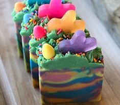 three soap bars with different colored frosting on them and the words happy daisy easter soap