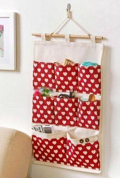 a red and white heart pattern hanging on a wall next to a chair with a magazine holder