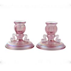 two pink glass candlesticks sitting on top of each other