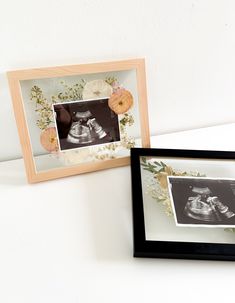 two framed pictures with baby shoes and flowers on the wall next to eachother