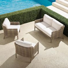 three wicker furniture sitting next to a swimming pool