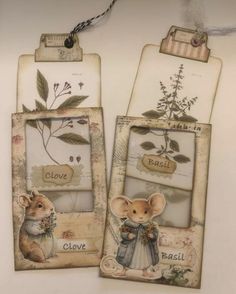 two tags with pictures of mice and flowers hanging from the side of a white wall