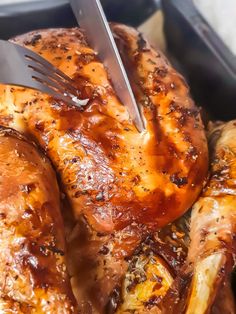 a close up of a chicken being cut with a knife and fork